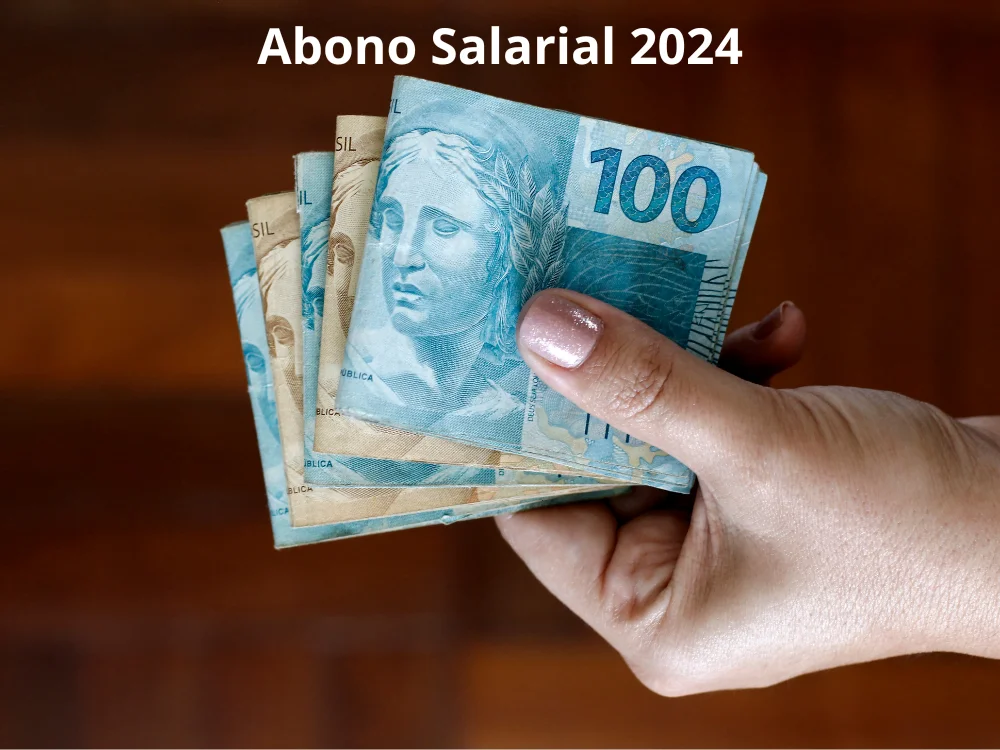 mão segurando algumas notas do Real