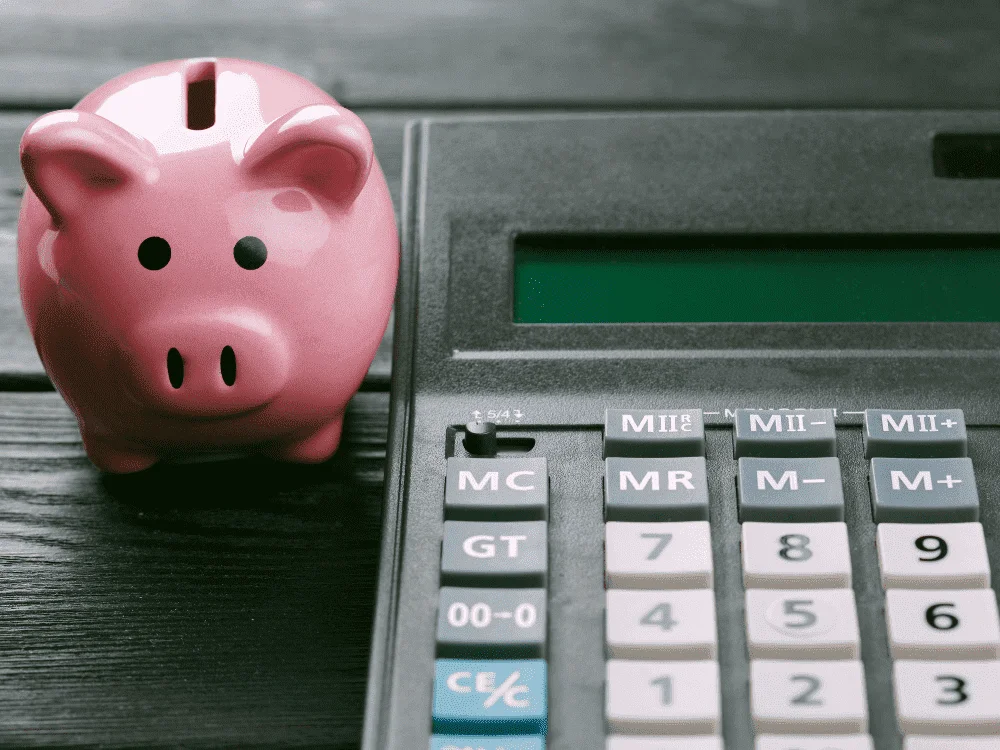 um cofre em formato de porco com uma calculadora ao lado