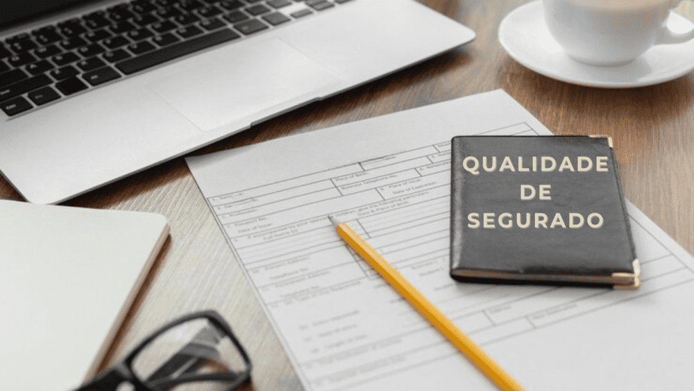 uma carteira de trabalho escrita qualidade de segurado em cima de um contrato e um lápis