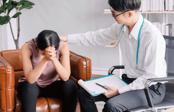 médico passando notícia para paciente que está ouvindo de cabeça baixa