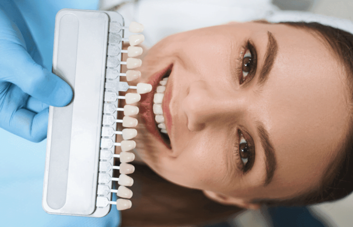 pessoa deitada na cadeira do dentista sorrindo fazendo moldura de um dente