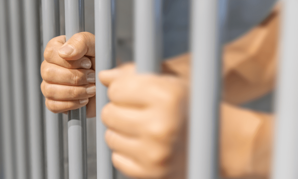 pessoa atrás de uma grade