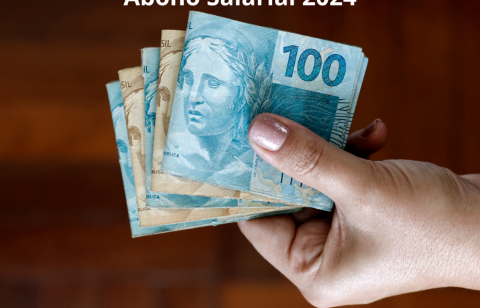 mão segurando algumas notas do Real