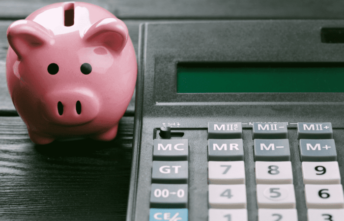 um cofre em formato de porco com uma calculadora ao lado